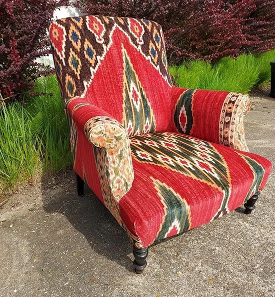 Fauteuil restauré en tissu rouge à motifs ethniques